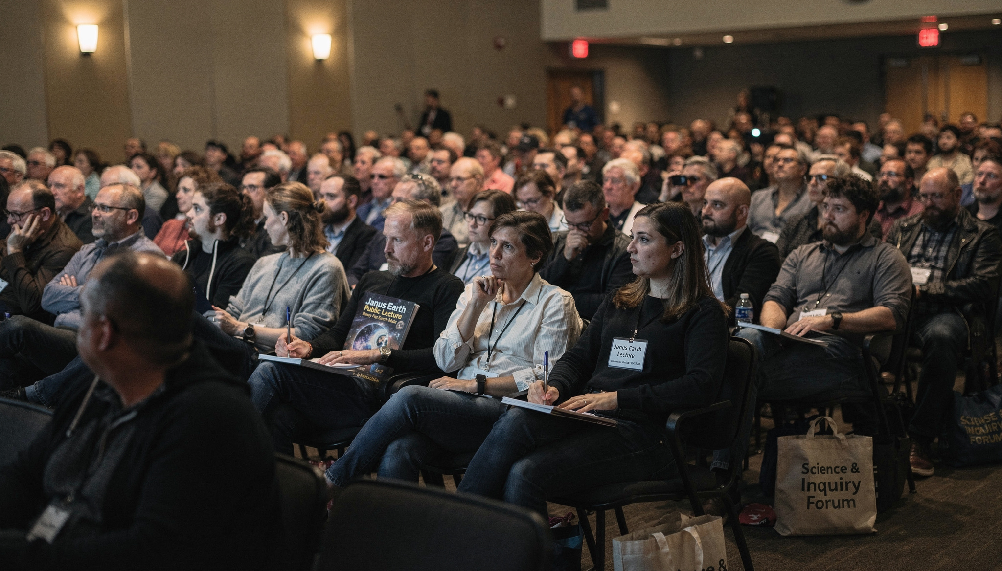 Wide audience room at a Janus Earth public forum