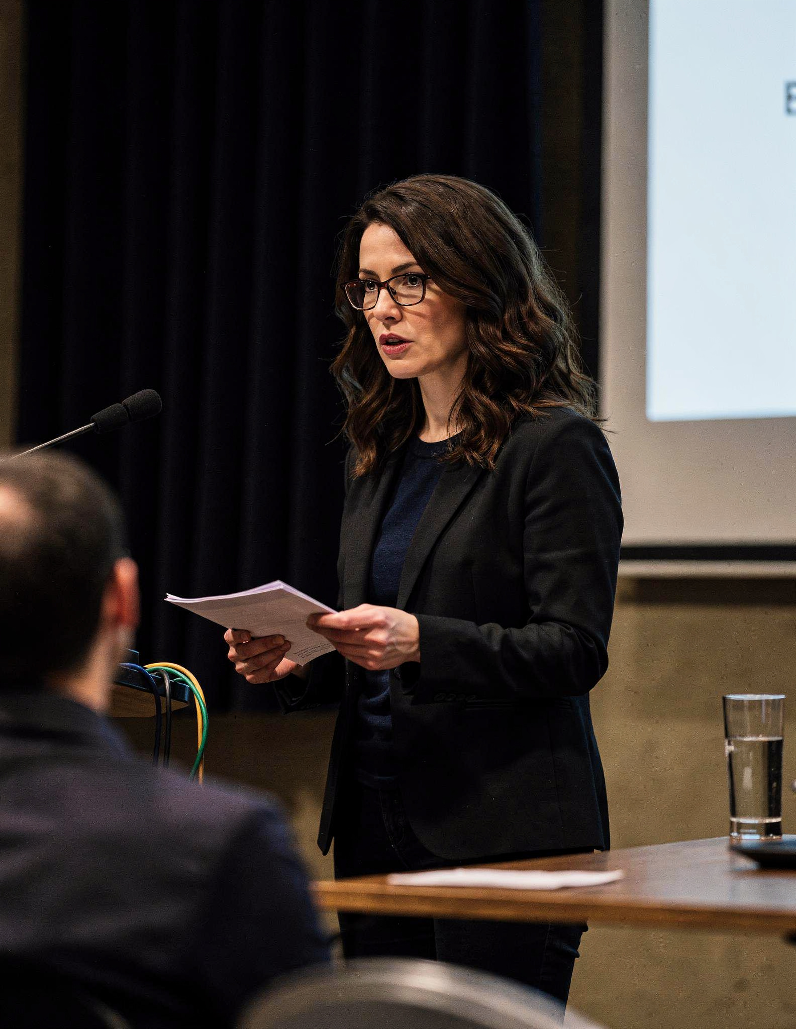 Tatiana Ardenne presenting from the lectern during a Janus Earth public session